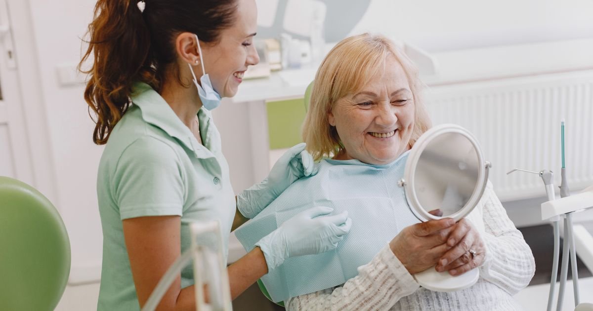 Senior woman at a dental check-up with her dentist, illustrating a visit to address bleeding gums