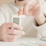 Woman checking a blood glucose meter at home