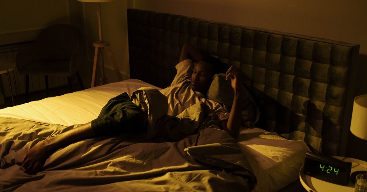 Older man lying awake in bed at night, illustrating frequent nighttime urination and disrupted sleep