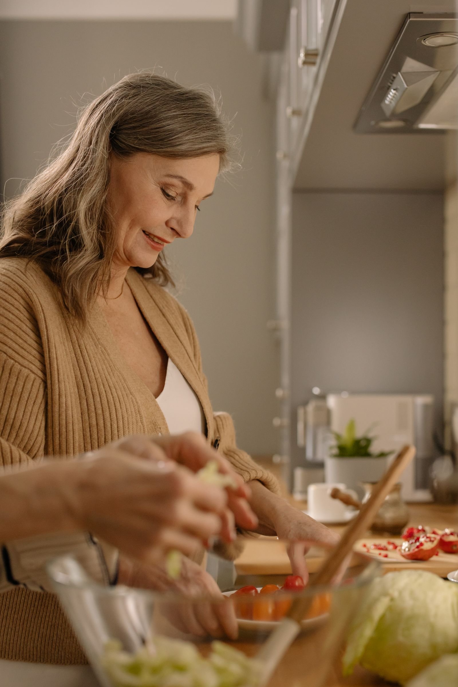 Elderly woman preparing a healthy, vegetable-forward meal in a bright kitchen