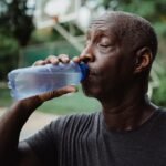 Senior man drinking water outdoors after activity