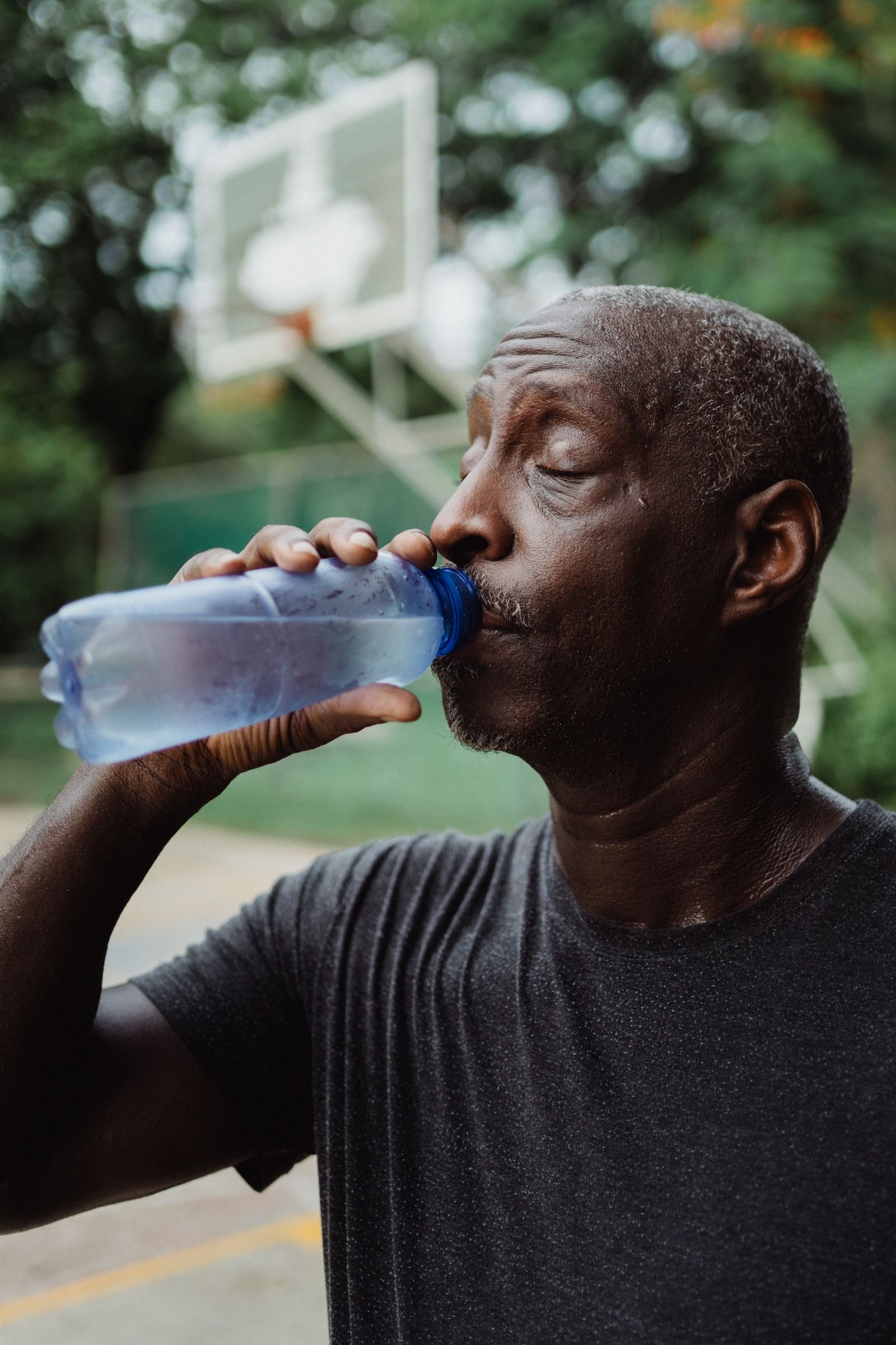 Senior man drinking water outdoors after activity