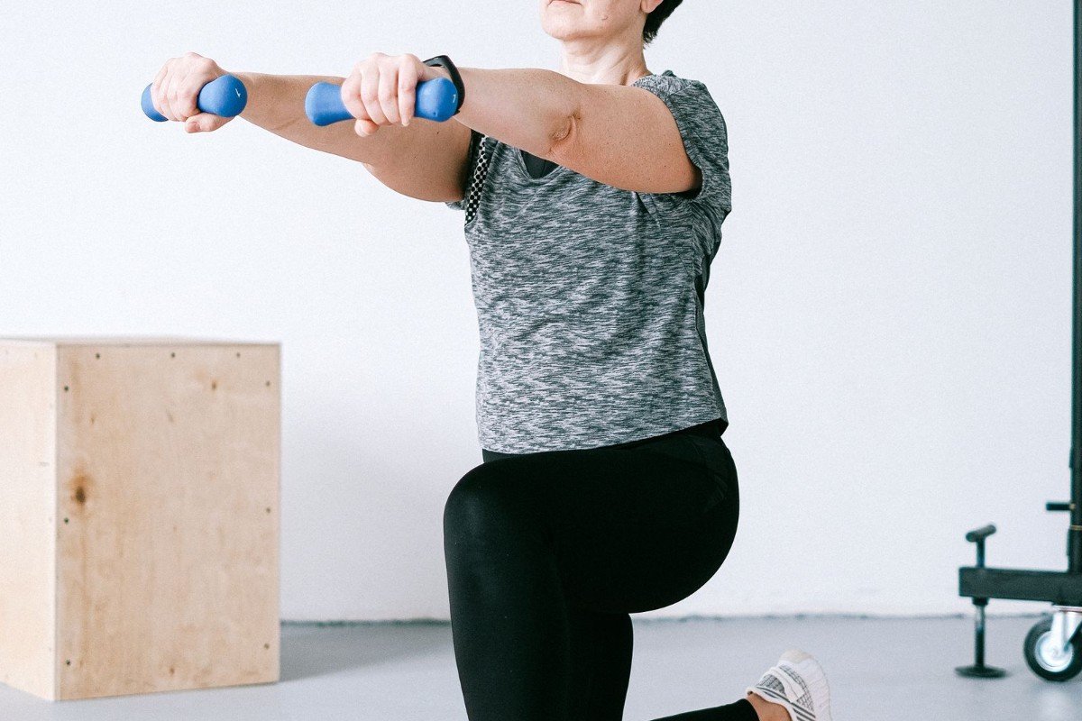 A senior woman using light dumbbells for strength training at home