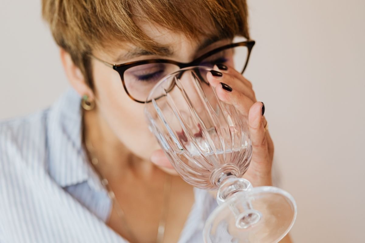 Woman with eyes closed drinking a glass of water