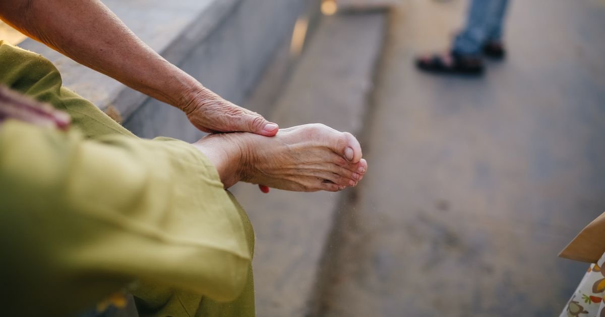 Close-up of an elderly person's hands massaging their foot for pain relief