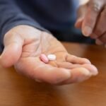 Close-up of a hand holding two pills, representing azithromycin dental antibiotic treatment
