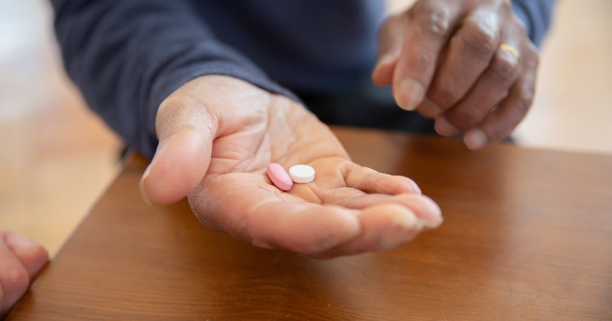 Close-up of a hand holding two pills, representing azithromycin dental antibiotic treatment