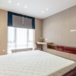 Clean bedroom with a bare mattress on a bed frame, the kind of spot where bed bugs commonly hide.