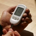 Hands using a blood glucose meter to check blood sugar levels