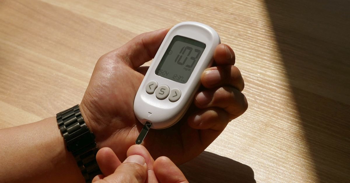 Hands using a blood glucose meter to check blood sugar levels