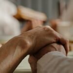 Elderly couple holding hands warmly during a family gathering