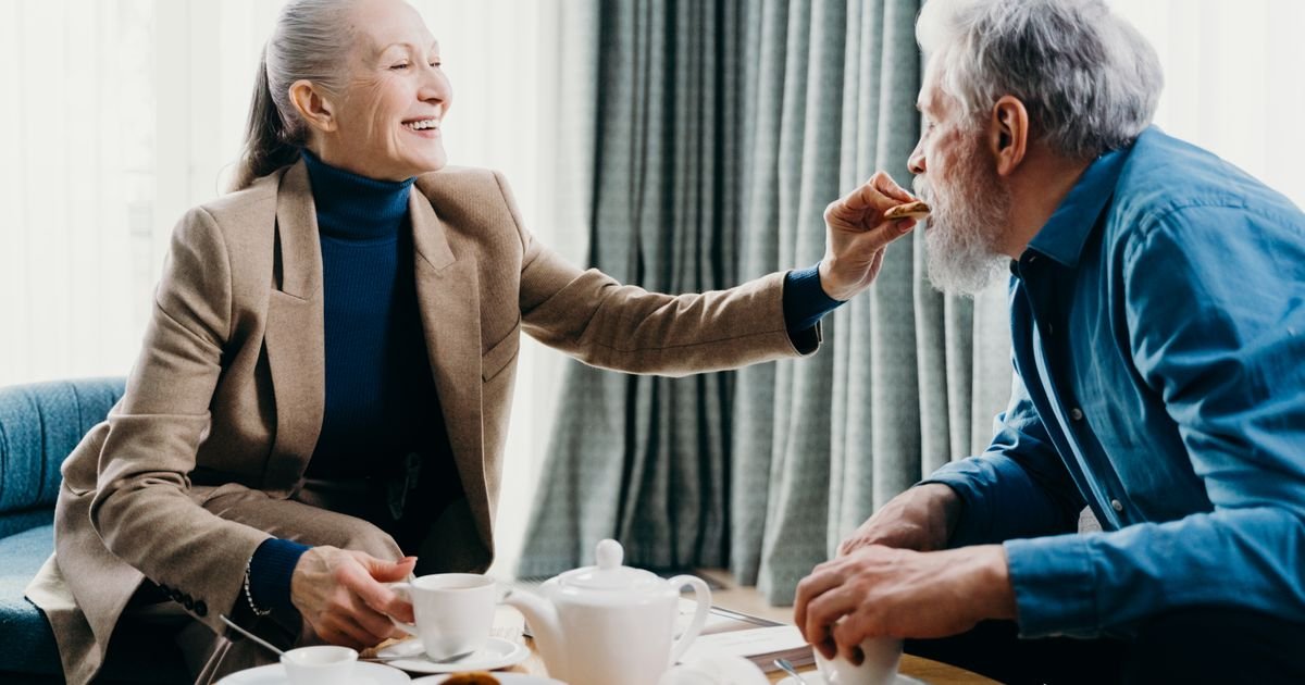 Senior couple smiling and sharing breakfast together