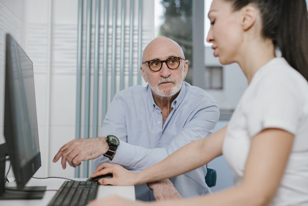Elderly man receiving a consultation from a medical practitioner
