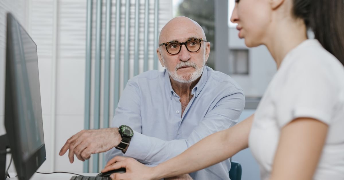 Mature man reviewing results on a screen with his doctor