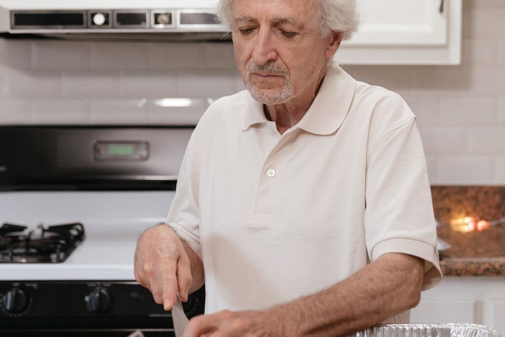 Senior man preparing fresh vegetables in a home kitchen
