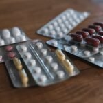 Several blister packs of pills and capsules arranged on a wooden table