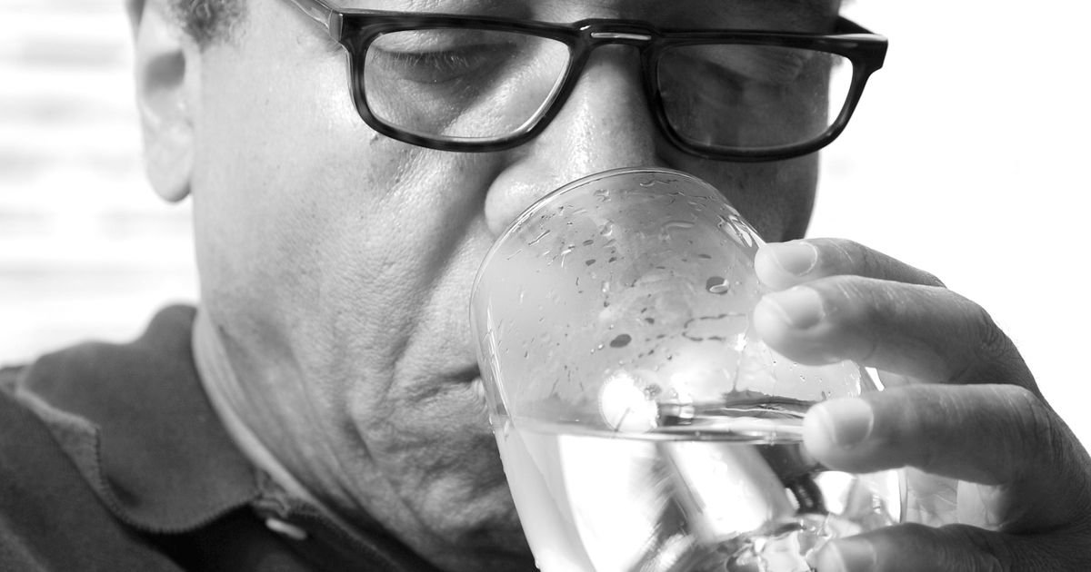 Older man drinking a glass of water