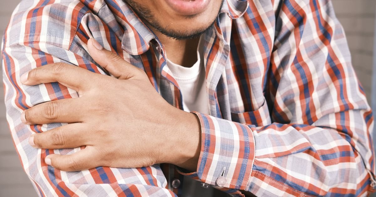 Hands providing gentle therapy to an older person's shoulder and upper back