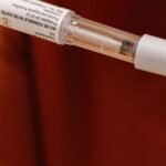 Close-up of a person using an injectable diabetes pen.