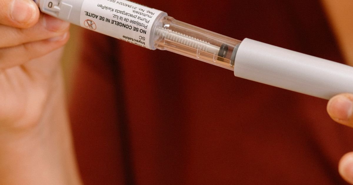 Close-up of a person using an injectable diabetes pen.